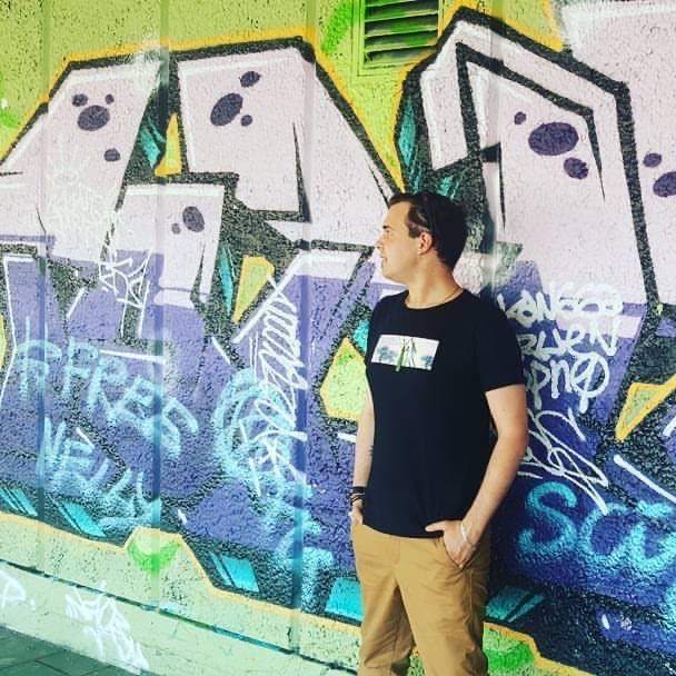 DJ T.L.K street style portrait in front of graffiti wall